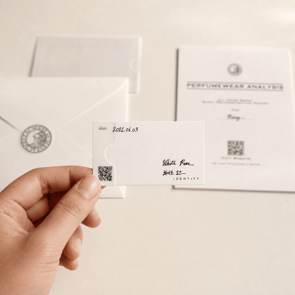 Scent Paper — Shows how the scent card feels in hand with the full kit softly in the background.